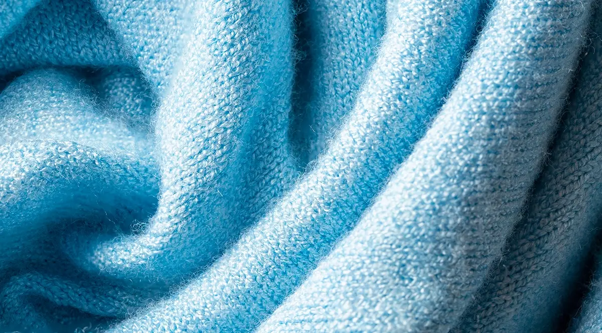 Close-up of blue knitted fabric texture, showcasing quality