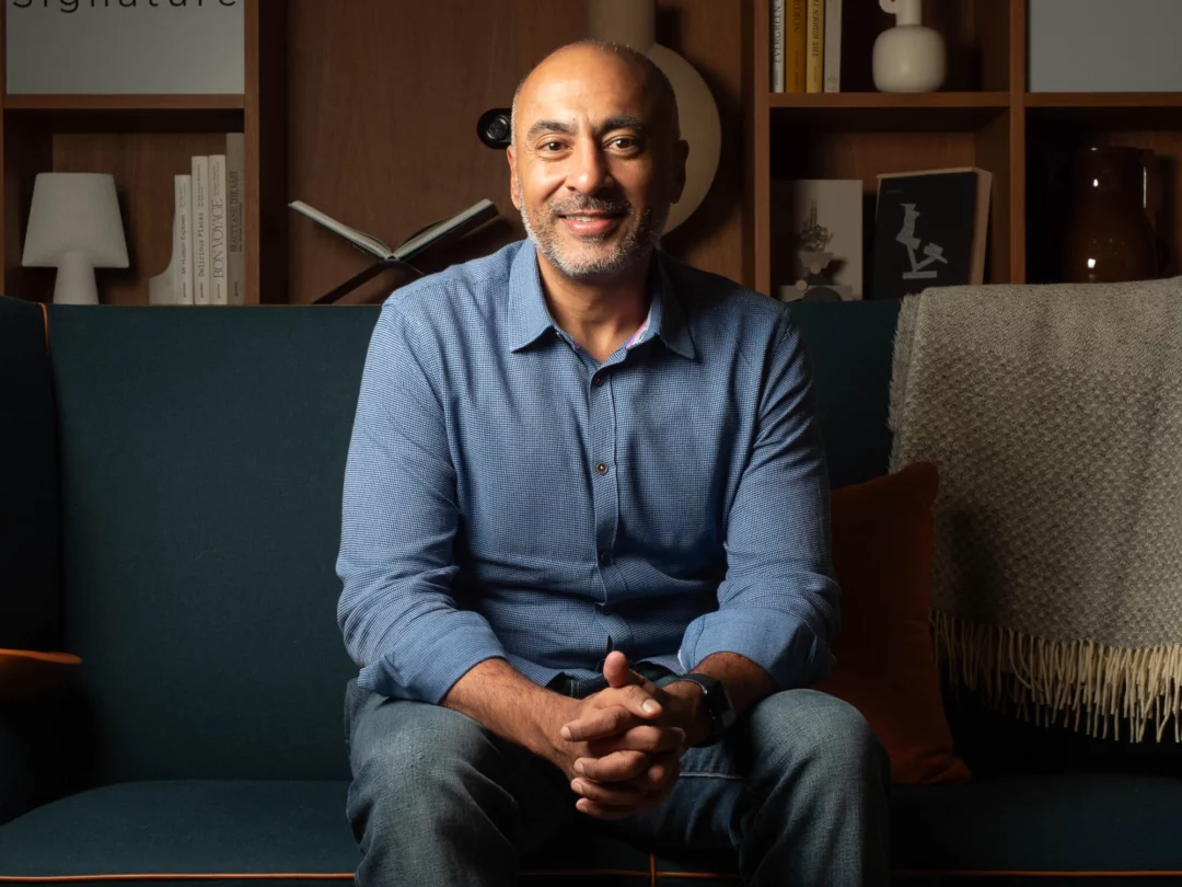 Chirag Patel, Inspectorio's new CEO, smiles at the camera, seated on a sofa.